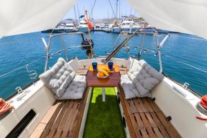 卡列罗港Seaside Chill-out Stay on a Sail Yacht的船上的木制甲板上配有桌椅