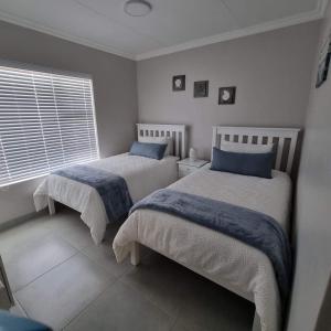 哈坦柏斯Perlemoen 301的一间卧室设有两张床和窗户。