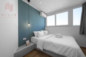 塞萨洛尼基V1 Penthouse, Nilie Hospitality MGMT的配有两张床铺的蓝色墙壁和窗户