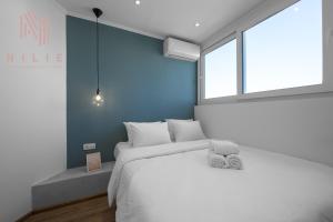 塞萨洛尼基V1 Penthouse, Nilie Hospitality MGMT的卧室配有白色的床和窗户。