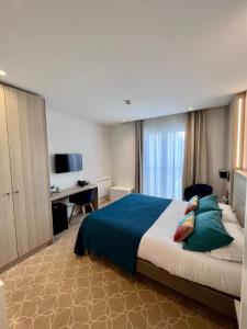 贝诺代Le Cornouaille Hotel & Spa的酒店客房设有一张大床和一张书桌。