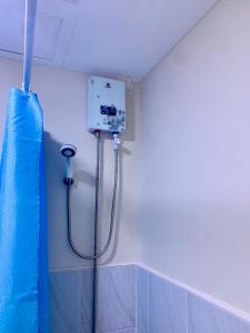 宿务Condo Near Mactan Airport的浴室设有蓝色淋浴帘和淋浴