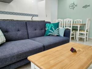 坎加斯德穆拉索罗德拉玛2A公寓的客厅配有蓝色的沙发和木桌