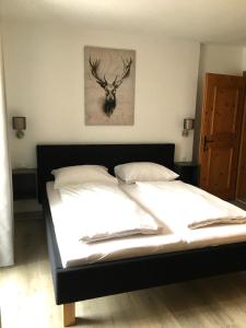 埃尔瓦尔德Landhaus Holzereck的卧室配有一张带鹿头的墙壁床。