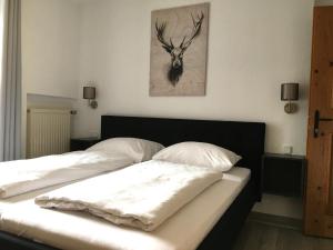 埃尔瓦尔德Landhaus Holzereck的一张带两个枕头的床和墙上的鹿画