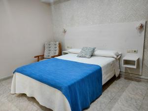 坎加斯德穆拉索罗德拉玛2A公寓的一间卧室配有一张带蓝色毯子的床