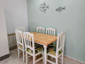 坎加斯德穆拉索罗德拉玛2A公寓的餐桌、白色椅子和木桌