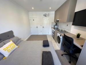 亨顿Bright Modern, 1 Bed Flat, 15 Mins Away From Central London的小房间设有床、书桌和厨房
