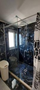 MantoúkionA flower house的带淋浴的浴室和黑色瓷砖墙