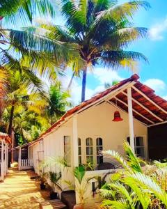 卡纳科纳Baywatch Beach Resort patnem的前面有棕榈树的房子