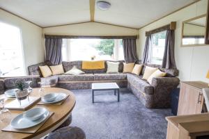 滨海克拉克顿Great 8 Berth Caravan For A Staycation In Clacton-on-sea Ref 26436e的客厅配有沙发和桌子