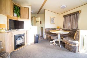 滨海克拉克顿Great 8 Berth Caravan For A Staycation In Clacton-on-sea Ref 26436e的一间带桌子和电视的小客厅
