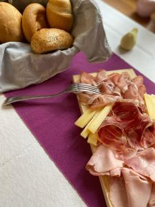 阿姆佩佐Residenza d'Epoca Albergo Grimani的盘子,包括肉奶酪和面包