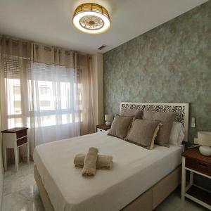 加的斯Apartamento reformado con vistas al mar的卧室设有一张白色大床和一扇窗户。