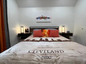 克利夫兰Trendy in Tremont, Cleveland (Upper)的卧室内的一张大床,配有两盏灯