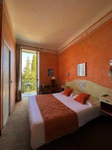 旺斯Hôtel Miramar的一间卧室配有一张带橙色墙壁的大床