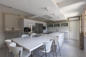 勒芒Villa Misano的白色的厨房配有大白色的桌子和椅子