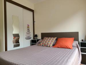 圣布里厄Meublé classé 3 étoiles的一间卧室配有一张带橙色枕头的床