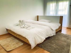 洛迦诺Vivere a Locarno - 5 minuti da Piazza Grande的卧室配有一张带白色床单和地毯的大床。