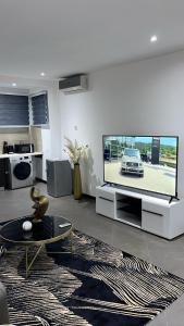 库马西Nuben Court- Kumasi City的客厅配有大屏幕平面电视