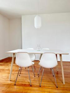 赖兴瑙Haus Münsterblick的白色餐桌和3把白色椅子