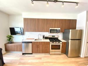 悉尼Lovely Brand New Suite的厨房配有木制橱柜和不锈钢用具