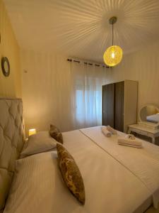乌尔齐尼Apartmens Xhenis Lux的卧室配有带枕头的大型白色床