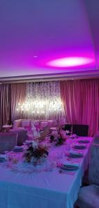 杰迪代AMWAJ HOTEL的一张带粉红色灯光和紫色天花板的长桌