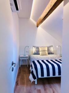 马托西纽什Matosinhos Beach Loft的一间卧室配有一张带黑白条纹毯子的床