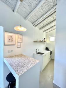 阿尔沃尔Casa XS的白色的厨房配有柜台和水槽