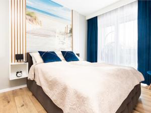 济夫努夫Alexis apartament Dziwnów的一间卧室配有一张带蓝色窗帘的大床