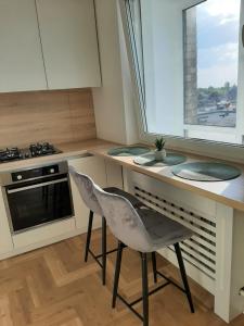希奥利艾Visinskio apartamentai的厨房配有带椅子和炉灶的台面