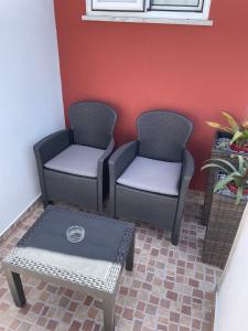 圣特奥托纽Alojamento Amor de Mãe的墙上有两把椅子和一张桌子