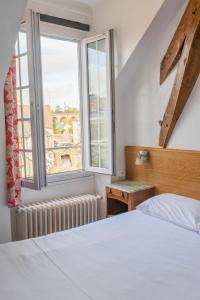 博让西Le Relais Des Templiers的卧室配有白色的床和窗户。