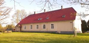 Pärnu-JaagupiPärnu-Jaagupi pastoraat的一座位于田野的红色屋顶的旧房子