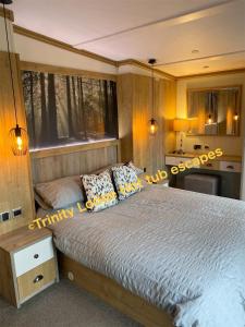 塔特舍尔Trinity lodge hot tub escapes at Tattershall lakes的一间卧室设有一张大床和一个窗户。
