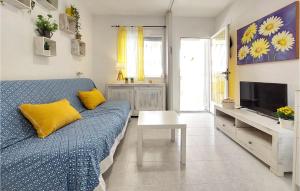 比纳罗斯Cozy Apartment In Vinaroz With Kitchen的客厅配有蓝色的沙发和电视