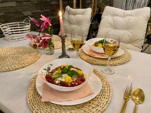 斯塔拉·里斯拉Vila GARUFA Wellness & Spa的一张桌子,上面放着两盘食物和两杯葡萄酒