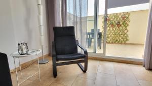 代尔特布雷Somnis del Delta的一张黑椅子坐在桌子旁,靠窗