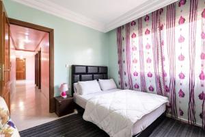 卡萨布兰卡Homestay, Private room ,Séjours chez l'habitant Casa Voyageurs的一间卧室设有一张床和一堵粉红色鲜花的墙壁