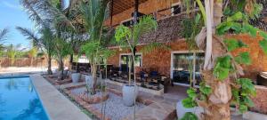 马特姆维Salama & Mbuyuni Bungalows的一座带游泳池和棕榈树的房子