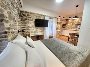 斯普利特Mariani studio apartments old town的一间卧室设有一张床和石墙
