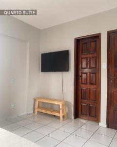 大坎皮纳Refúgio Urbano的一间设有壁挂式电视和木桌的房间