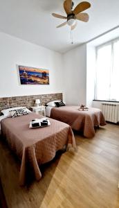 热那亚Appartamento Sofia a Genova的一间卧室配有两张床和吊扇