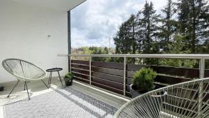 温特贝格INSIDE WINTERBERG - Design Apartment - Ski Bike Sauna的阳台配有椅子,享有树林美景