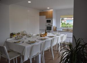 蒙考Casa dos Picoutos AL的餐桌、白色椅子和厨房