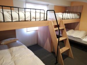 千岁Hotel Raffinato Chitose的客房设有两张双层床和一张床。