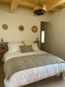 圣雷米普罗旺斯Mazet Le Micocoulier的卧室内的一张白色大床,拥有木制天花板