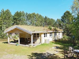 YderbyHoliday home Sjællands Odde VI的一座带草屋顶的小房子,设有庭院