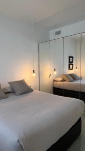 拉尔法斯德尔皮VIP Alfaz del Pi的一间白色卧室,配有两张床和两盏灯。